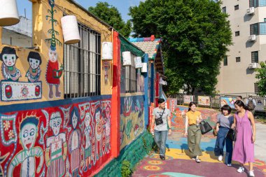 Turistler Gökkuşağı köy, renkli grafiti ev boyalı ziyaret edin. İnsanların duvarlardaki renkli resimleri ve illüstrasyonları görebileceği bir seyahat yeri. Taichung, Tayvan - 27 Ağustos 2019