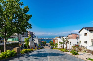 Yazın Hachiman-zaka yamacının manzarası güneşli bir günde beyaz bulutlar ve bule gökyüzü. Eğik bir cadde, filmlerde ve reklamlarda ünlü oldu. Hakodate City, Hokkaido, Japonya 'da Popüler Manzaralar