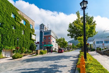 Hakodate, Hokkaido, Japonya - 15 Temmuz 2018: Güneşli yaz günlerinde Hachiman-zaka yamacının manzarası beyaz bulutlar ve bule gökyüzü. Eğik bir cadde, filmlerde ve reklamlarda ünlü oldu. Popüler Manzara Mekanı