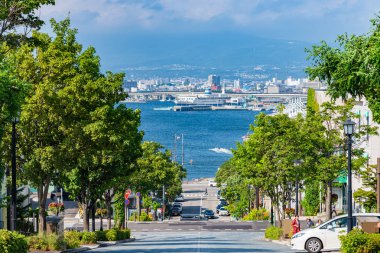 Hakodate, Hokkaido, Japonya - 15 Temmuz 2018: Güneşli yaz günlerinde Hachiman-zaka yamacının manzarası beyaz bulutlar ve bule gökyüzü. Eğik bir cadde, filmlerde ve reklamlarda ünlü oldu. Popüler Manzara Mekanı