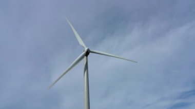 Güneşli bir günde mavi gökyüzü ve beyaz bulutlarla yakın çekim rüzgar türbinleri veya rüzgar enerjisi dönüştürücüsü
