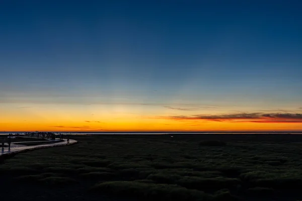 Die malerische Brücke über den Touristenpfad am Meer leuchtet bei Sonnenuntergang mit rosigen Wolken. Gaomei Feuchtgebiete, Taichung City, Taiwan — Stockfoto