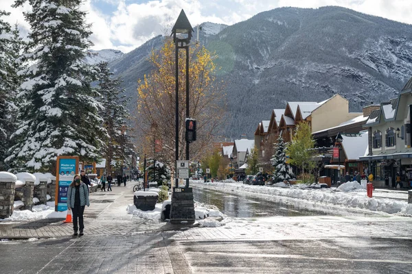 Banff, Alberta, Canadá - OCT 14 2020: Vista de la calle de Banff Avenue en otoño e invierno temporada nevada día soleado durante el período covid-19 pandemia. — Foto de Stock