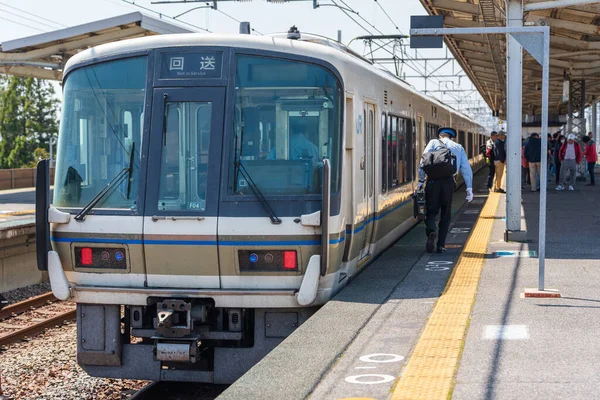 Otsu, Shiga, Japonya - 12 Nisan 2025: JR West yerel treni Omi-Maiko İstasyonu 'nda durdu, bir kondüktör platform boyunca yürüyordu..