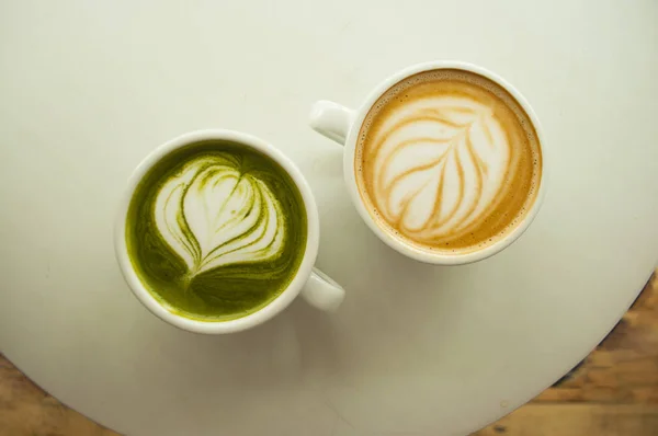 İki bardak matcha çay ve kapuçino güzel latte art gri renk tablosu tarih ile.