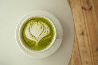 Matcha çay güzel latte sanat bir kafede gri bir tablo ile.
