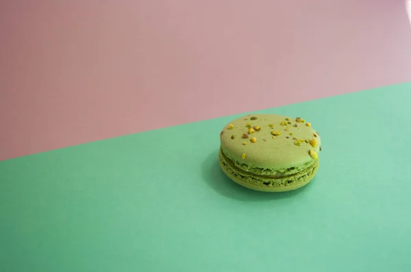 Green color macaron on purple background. — Stock Photo, Image