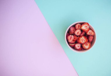 Pembe kase metin alanı ile dolu pastel pembe ve mavi arka plan üzerinde güzel taze sulu çilek.