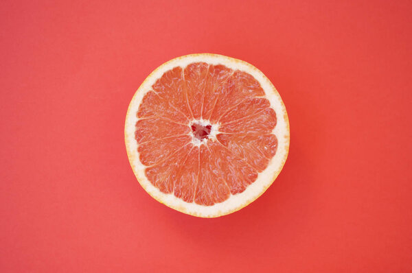 Beautiful juicy cut grapefruit on red background.