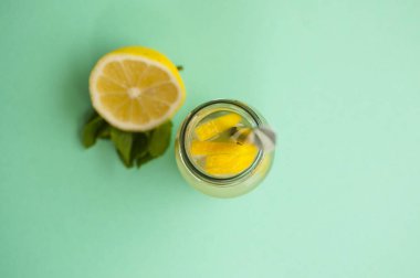 Turkuaz arka plan üzerine nane ve mason kavanoza bardak limonata veya limon ile mojito görünümünü top.