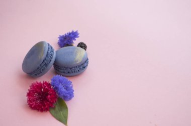 Bademli kurabiye, çiçek ve meyveleri pembe bir arka plan üzerinde.