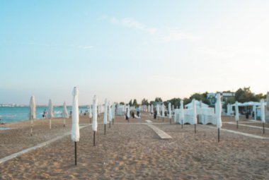 Günbatımı üzerinde kapalı şemsiye ile bulanık arka plan oof yaz kumlu plaj.