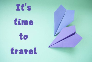 Düz metin alanı ile iki mor kağıt uçakların pastel pembe ve mavi zemin üzerinde yatıyordu.