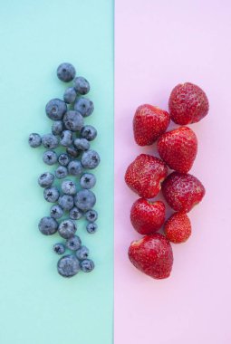 Lezzetli böğürtlen ve çilek pastel renkli arka plan üzerinde.