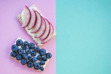 Düz yaban mersini ve apple sandviç pastel renkli arka plan üzerinde yatıyordu.