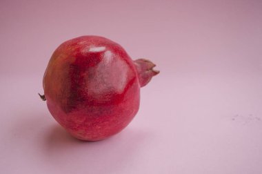 Olgun kırmızı nar meyve ile boşaltmak pembe bir arka plan üzerinde düz lay.