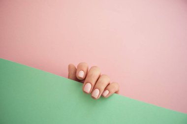 Güzel genç kadının el pembe ve sarı zemin üzerine.