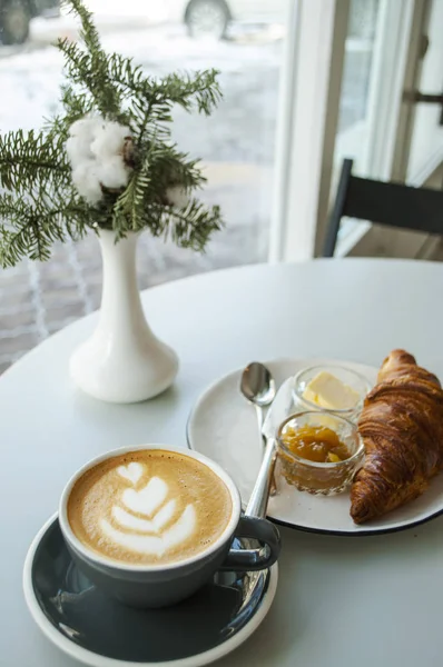 Croissant mit Marmelade, Butter und einer Tasse Kaffee. — Stockfoto