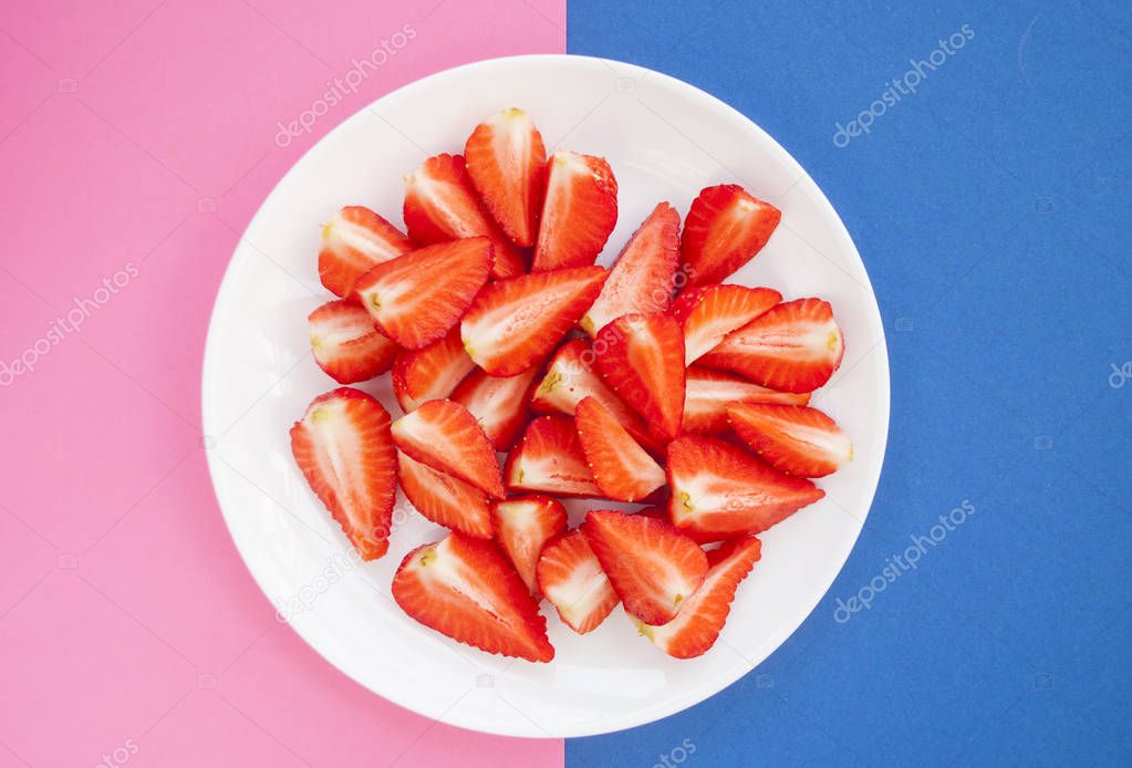 Top view of fresh strawberries on white plate.
