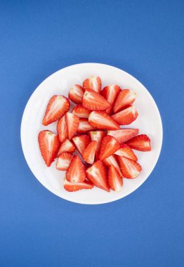 Beyaz tabakta taze çilek üst görünümü.