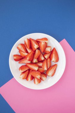 Beyaz tabakta taze çilek üst görünümü.