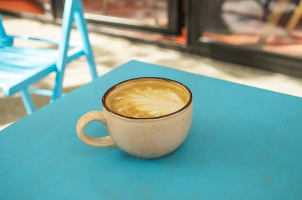 Secangkir kopi di atas meja biru. — Stok Foto