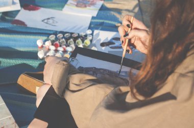 Genç bir kadın resim çiziyor..