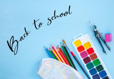 Renkli kalemler, suluboya, copyspace ile mavi arka plan holografik kalem kutusu. Düz döşeme tarzı. Okul konseptine geri dön.