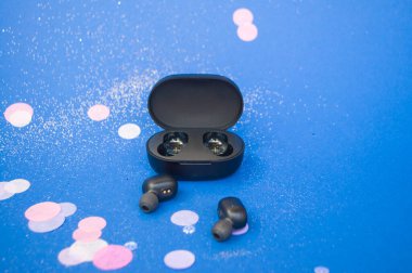 Kulaklıklar parlak sarı ve klasik mavi arka planda renkli konfeti ve kıvılcımlarla. Neşeli arkaplan.