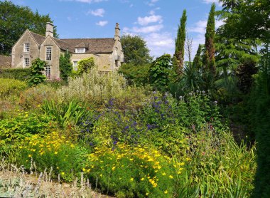 İngiltere'nin Cotswolds bölgesinde güzel peyzajlı bir bahçede karışık otlu sınır