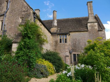 İngiltere'nin Cotswolds bölgesinde güzel peyzajlı bir bahçede karışık otlu sınır