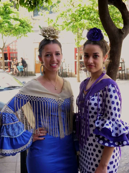 Seville İspanya/14 Nisan 2013 / iki güzel genç Spannish güzel bayanlar yıllık Nisan bahar adil yürüme geleneksel elbiseler düzenlenen Sevilla şehir İspanya'parlak mavi