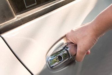 beyaz arabanın kapısını açarak sapında el