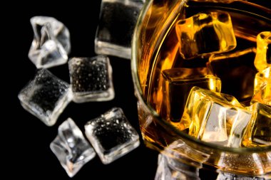 Siyah arka planda buz küplü viski.