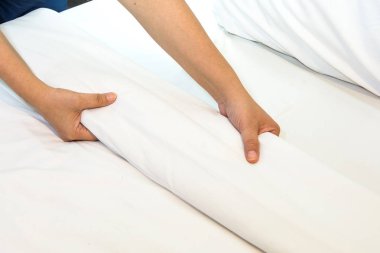 Beyaz çarşaf yatak odasında el kurmak