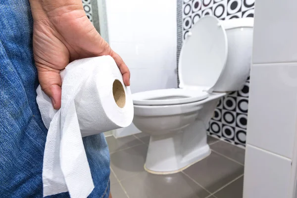 Рука держит туалетную бумагу Paper.diarrhea запор. Лицензионные Стоковые Фото