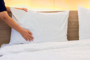 el yatak çarşafı üzerinde beyaz yastık kurmak 