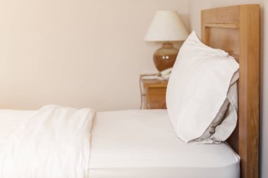 Beyaz yatakta beyaz yastık. Yatakta rahat bir süs.