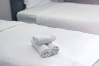 Otel odasının yatak odasındaki beyaz havlular.