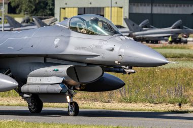 FLORENNES, BELGIUM - JUN 15, 2017: Air Force F16 fighter jet aircraft taxiing towards the runway of Florennes airbase. clipart