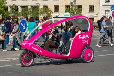 BERLIN, GERMANY - APR 28, 2018: Velotaxi bike taxi with customers cycling through the streets of Berlin. clipart