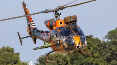 GILZE-RIJEN, THE NETHERLANDS - SEP 7, 2016: Special tiger painted French Army Gazelle military helicopter take-off. clipart