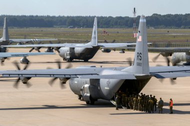 Paratroopers entering a US Air Force C-130 Hercules transport plane on Eindhoven airbase. clipart