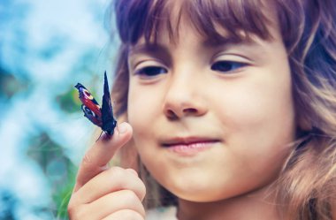 Çocuk elinde bir kelebek ile. Seçici odak.
