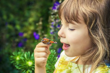 Çocuk elinde bir kelebek ile. Seçici odak.