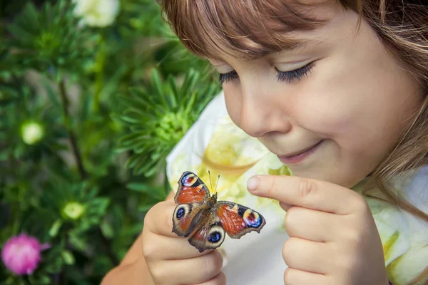 Çocuk elinde bir kelebek ile. Seçici odak.