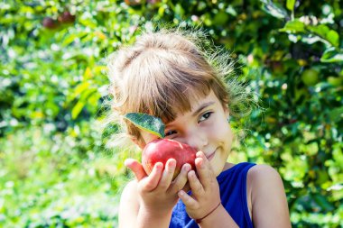 Çocuk bahçede elma yiyor. Seçici odak.