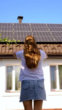 Adam evin çatısındaki güneş panellerine bakıyor. Seçici odaklanma. insanlar.