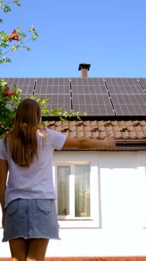 Adam evin çatısındaki güneş panellerine bakıyor. Seçici odaklanma. insanlar.