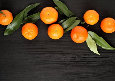 Siyah ahşap arka plan üzerinde bir sepet içinde Mandalina. Meyve sağlıklı gıda